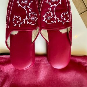 Deep pink leather slippers .
